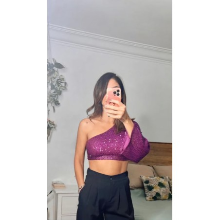 Vista por delante de top de lentejuelas, de color rosa, con una manga solo.