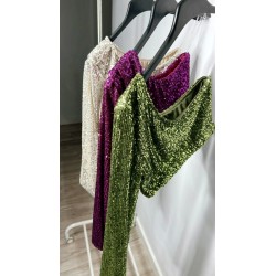 Vista de tres tops de lentejuelas,con una manga, colgados en perchas de colores blanco,rosa y verde.