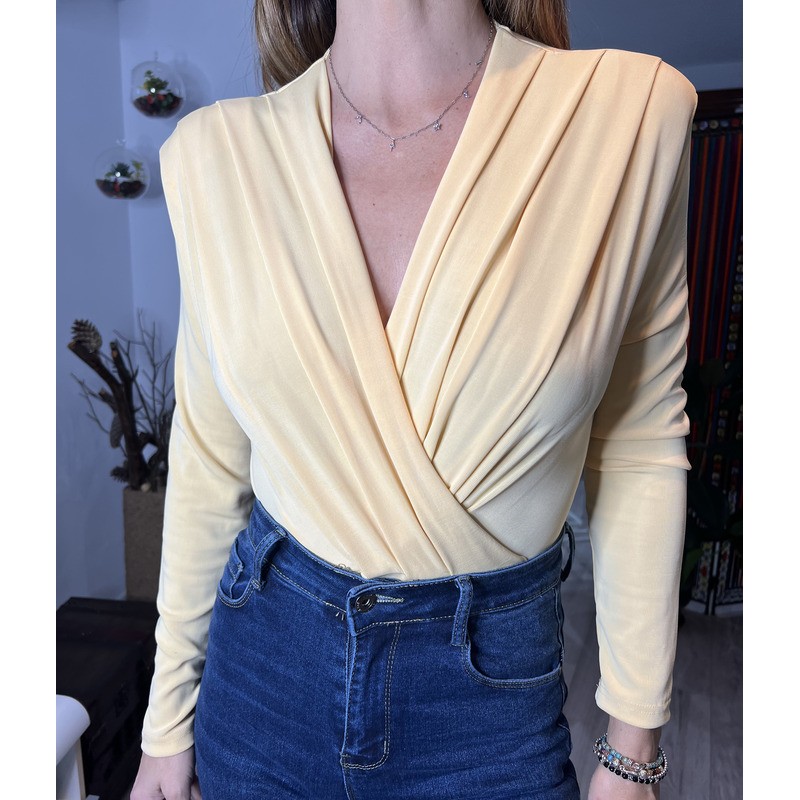Body de manga larga con cuello de pico , amarillo y visto por delante.