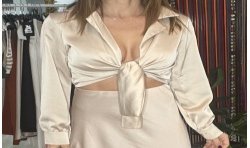 Blusa de manga larga de raso de color champagne vista por delante de raso anudada.