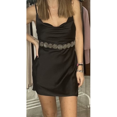 Vestido corto negro con tirantes con un cinturón puesto, visto por delante.