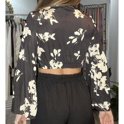 Vista por detrás de blusa negra con estampado floral en blanco.