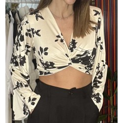 Blusa en blanco con estampado floral en negro.