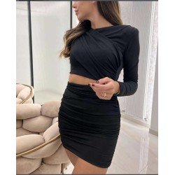 Vestido negro ajustado, de manga larga y con hombreras visto por delante.