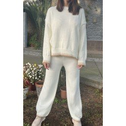 Conjunto de punto de dos piezas, de color blanco, pantalón un poco ancho por debajo y jersey manga larga, visto por delante.