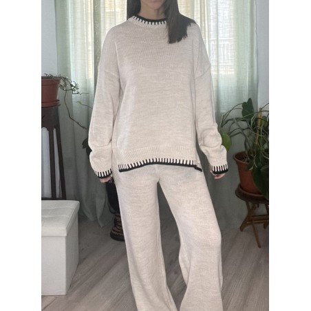 Conjunto de punto de colir beige, de dos piezas, pantalón un poco ancho por debajo y jersey de manga larga, visto por delante.