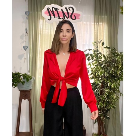 Blusa roja de manga larga de raso anudada vista por delante.