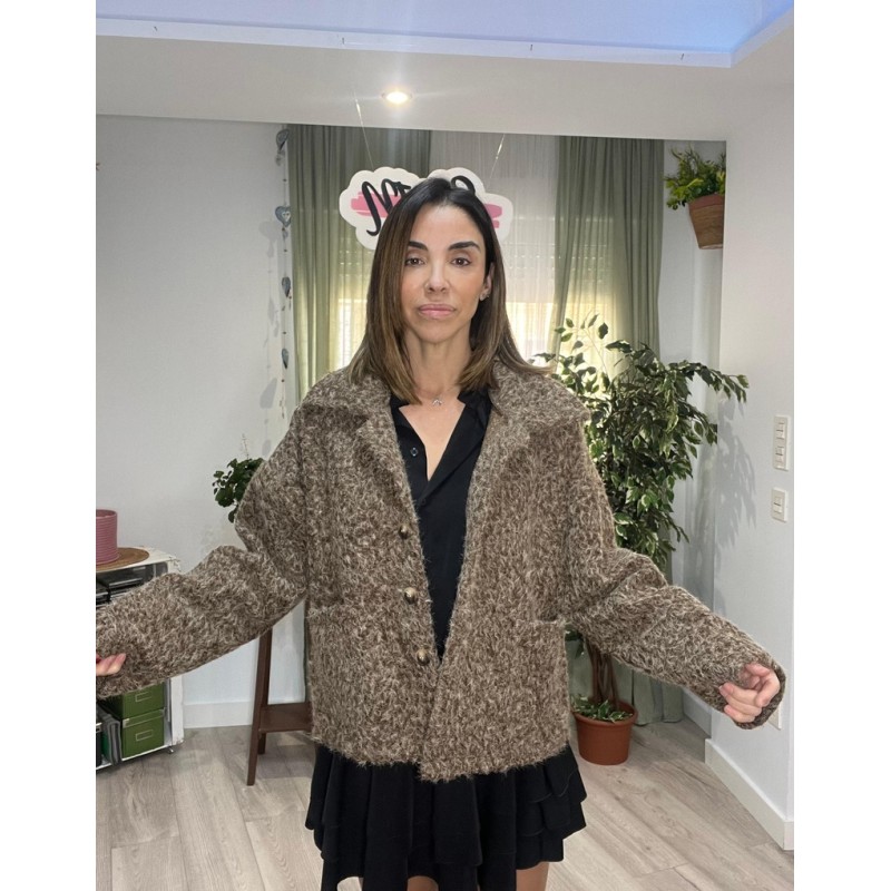 Chaqueta marrón con botones semi abierta.