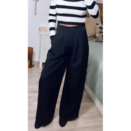 Pantalón negro de vestir ancho, con bolsillos, visto por delante.