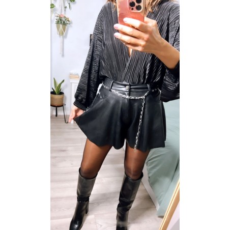 Pantalón corto de polipiel, con cadenita plateada de cinturón de adorno, visto por delante.